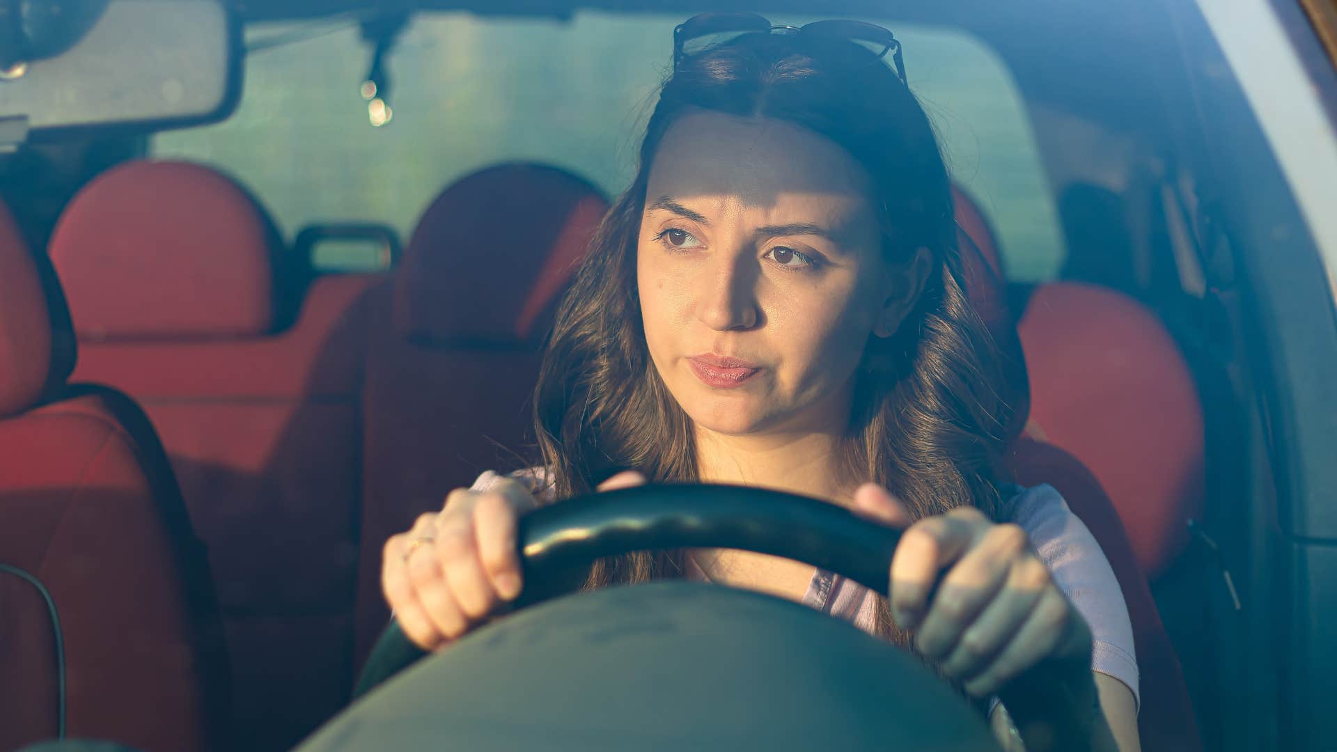 Hypervigilant woman looking serious while driving in her car. 