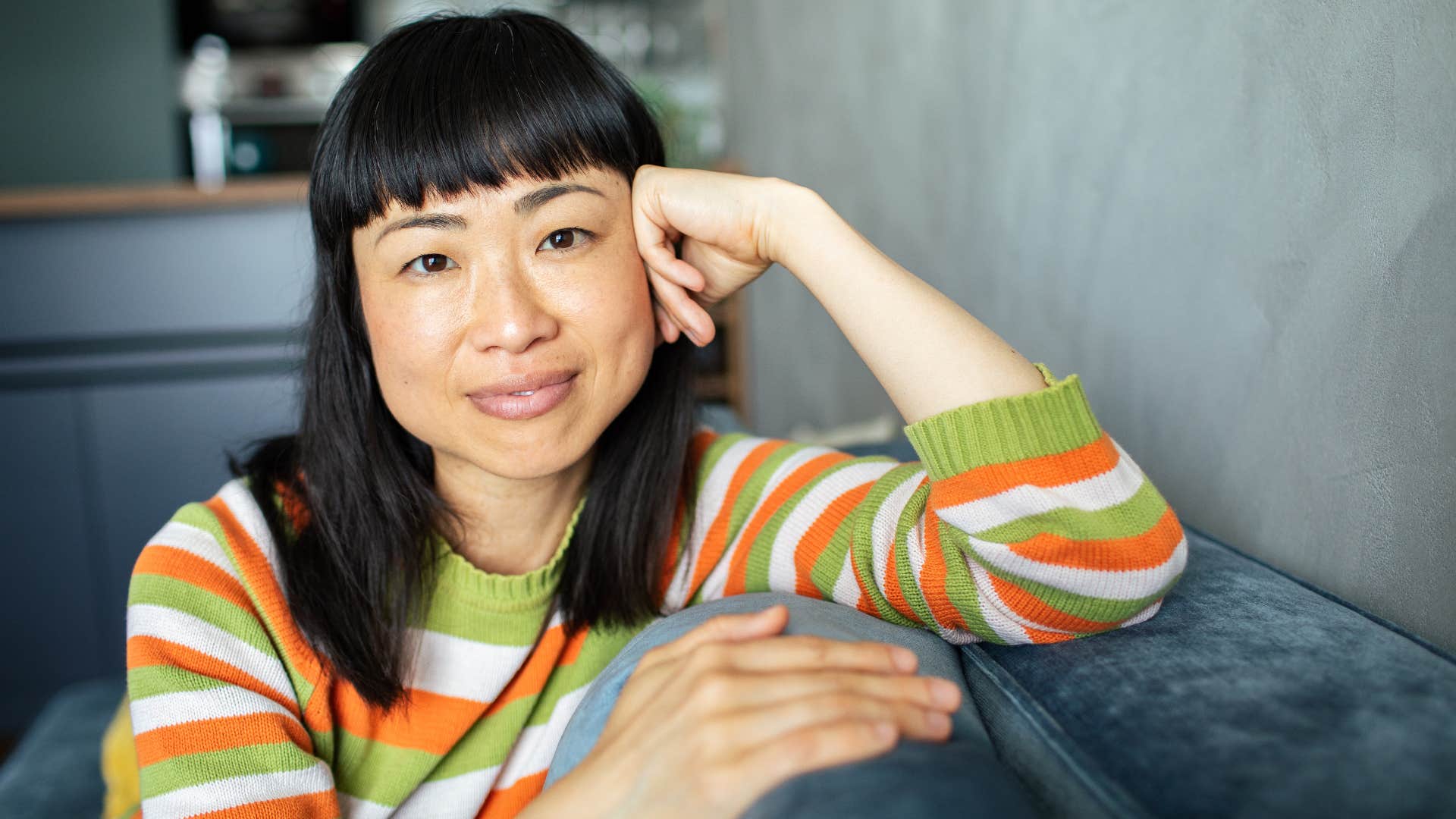 empowered woman smiling on her couch at home