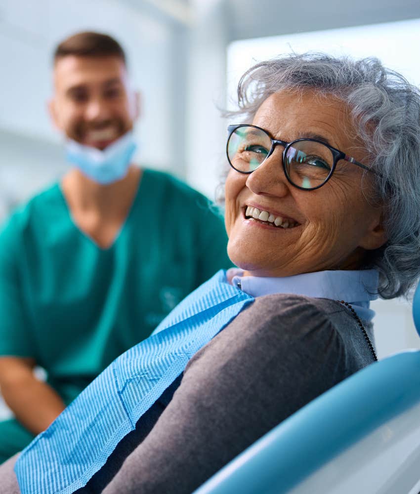 Smiling person at dentist showing gum issues and bad teeth