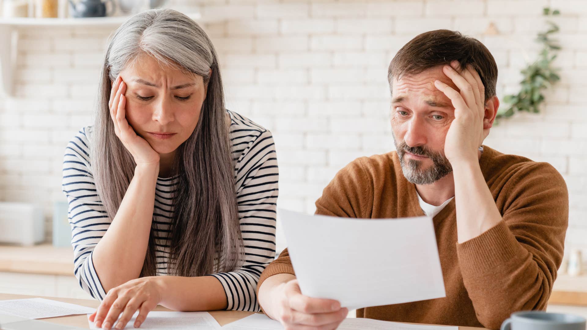 Sad couple hands off financial control and disengages completely