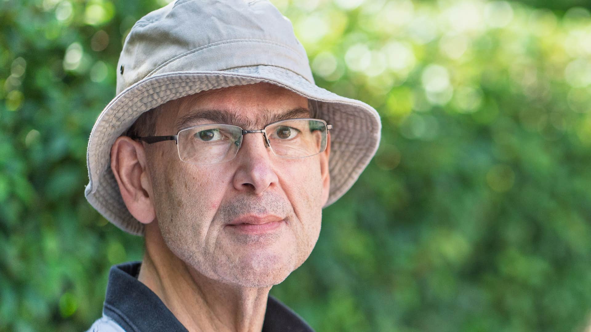 serious older man standing outsde