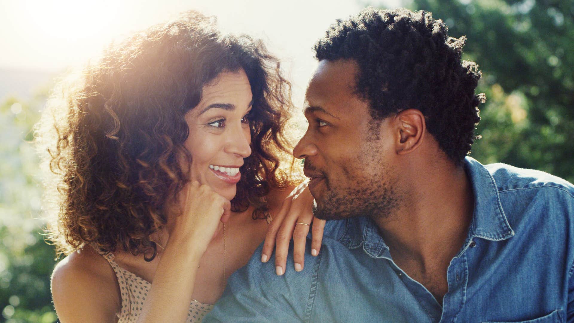 Romantic man moves close to woman showing way tot ell he loves you