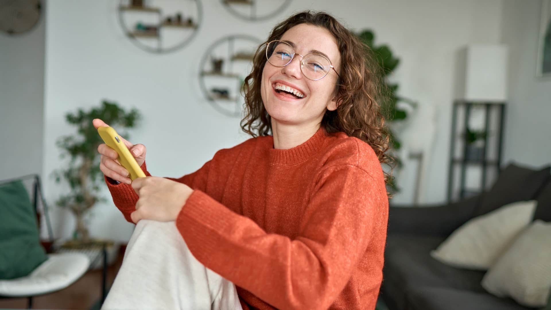 Happy woman reads text message showing way to tell he loves you