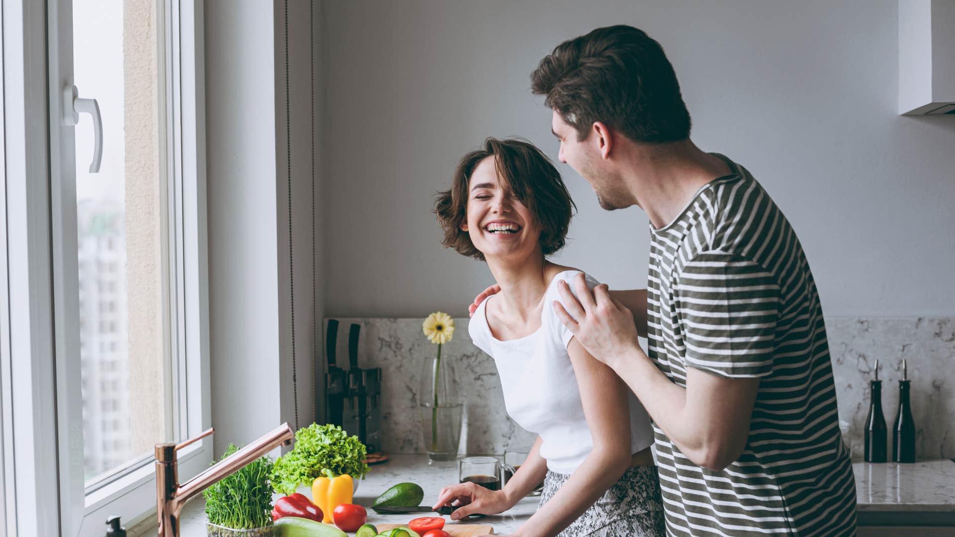 Happy man touches laughing woman showing way to tell he loves you