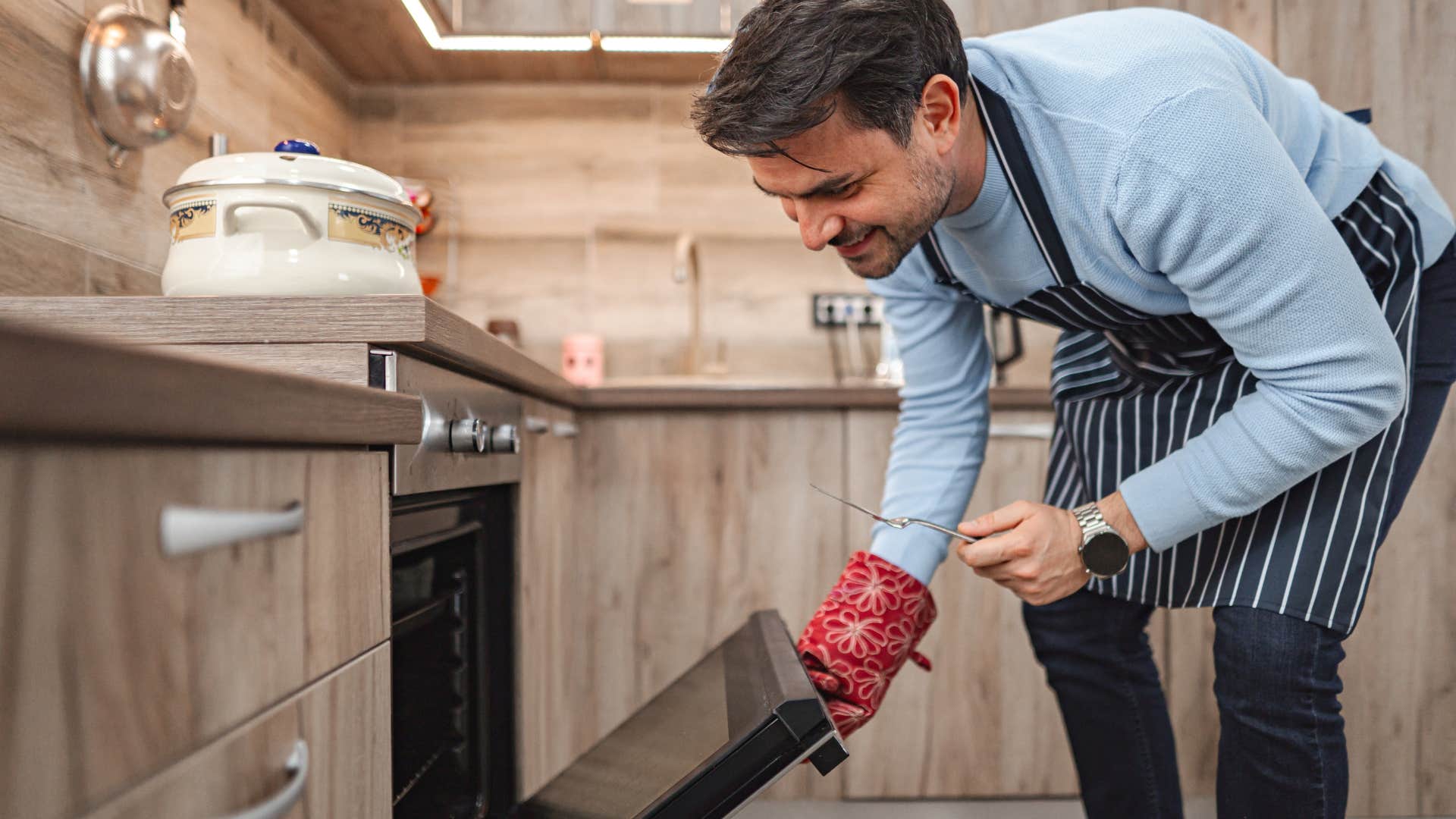 man cooking dinner in a broken oven