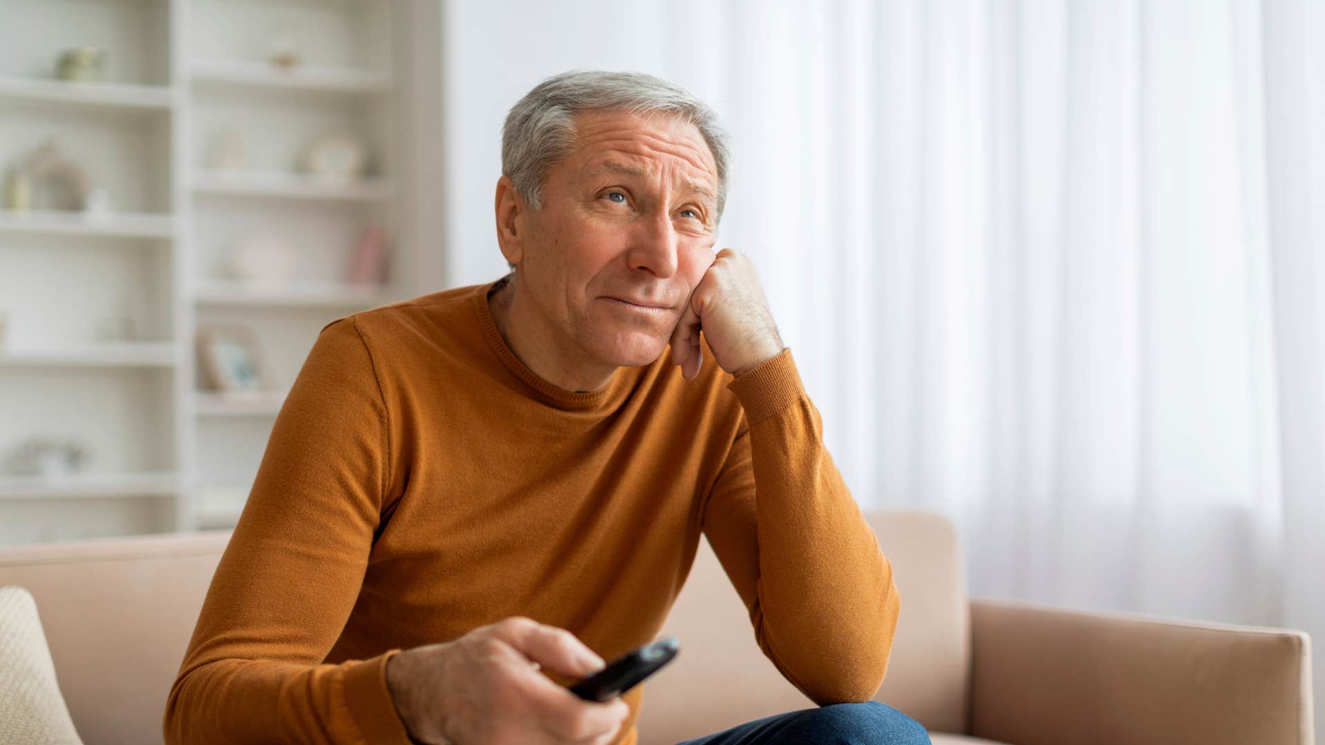 man whose life is collapsing watching tv at home