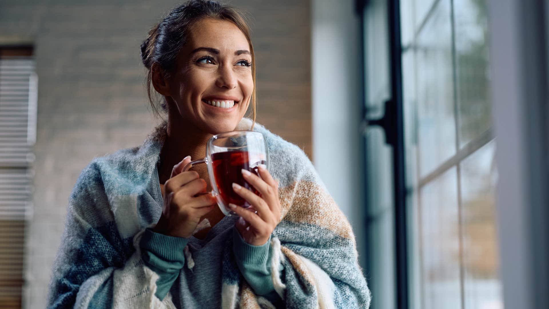 woman relaxing wearing a blanket at home