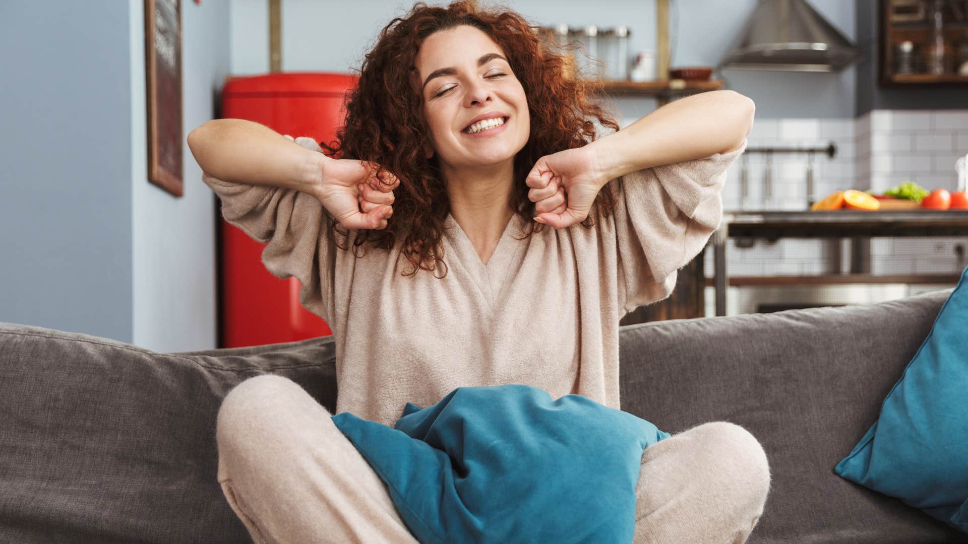 woman stretching on couch wearing comfy clothes