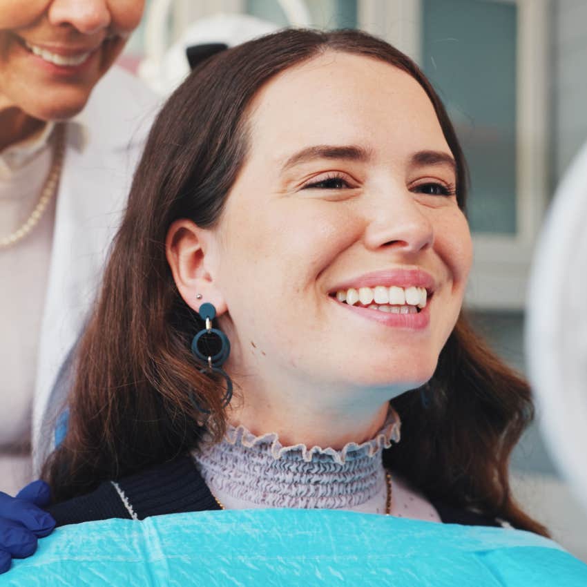 woman smiling and looking into mirror