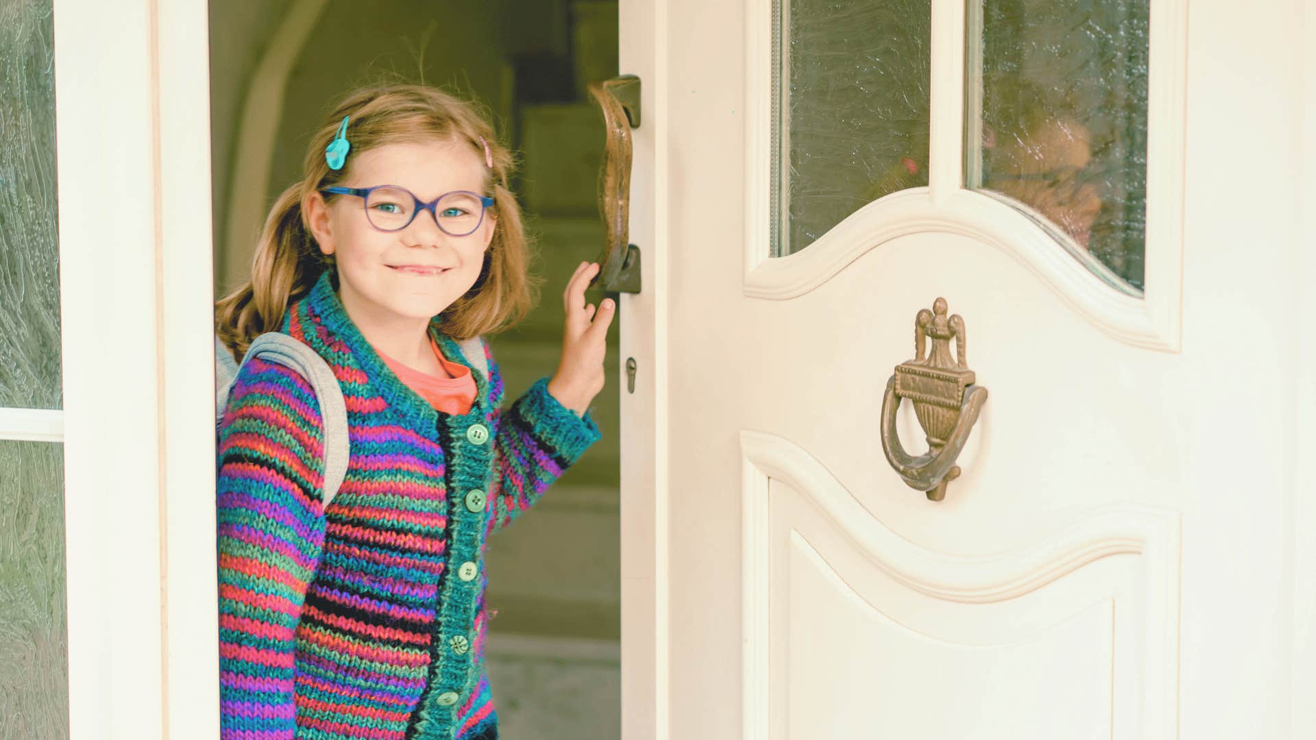 young girl opening front door