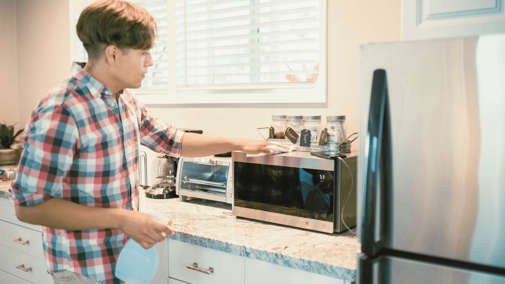 young man cleaning microwave