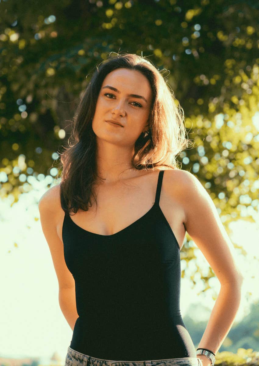 young woman in a black tank top outdoors