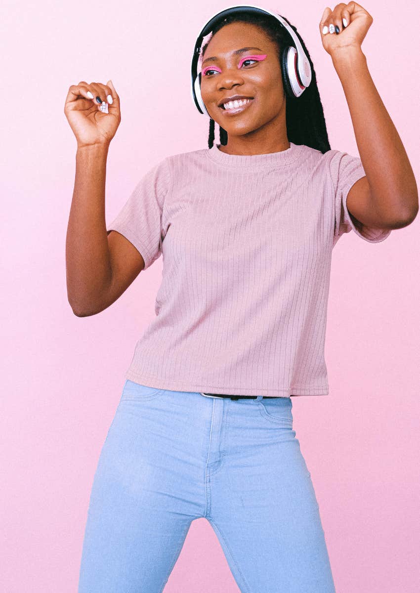 young woman dancing while wearing headphones