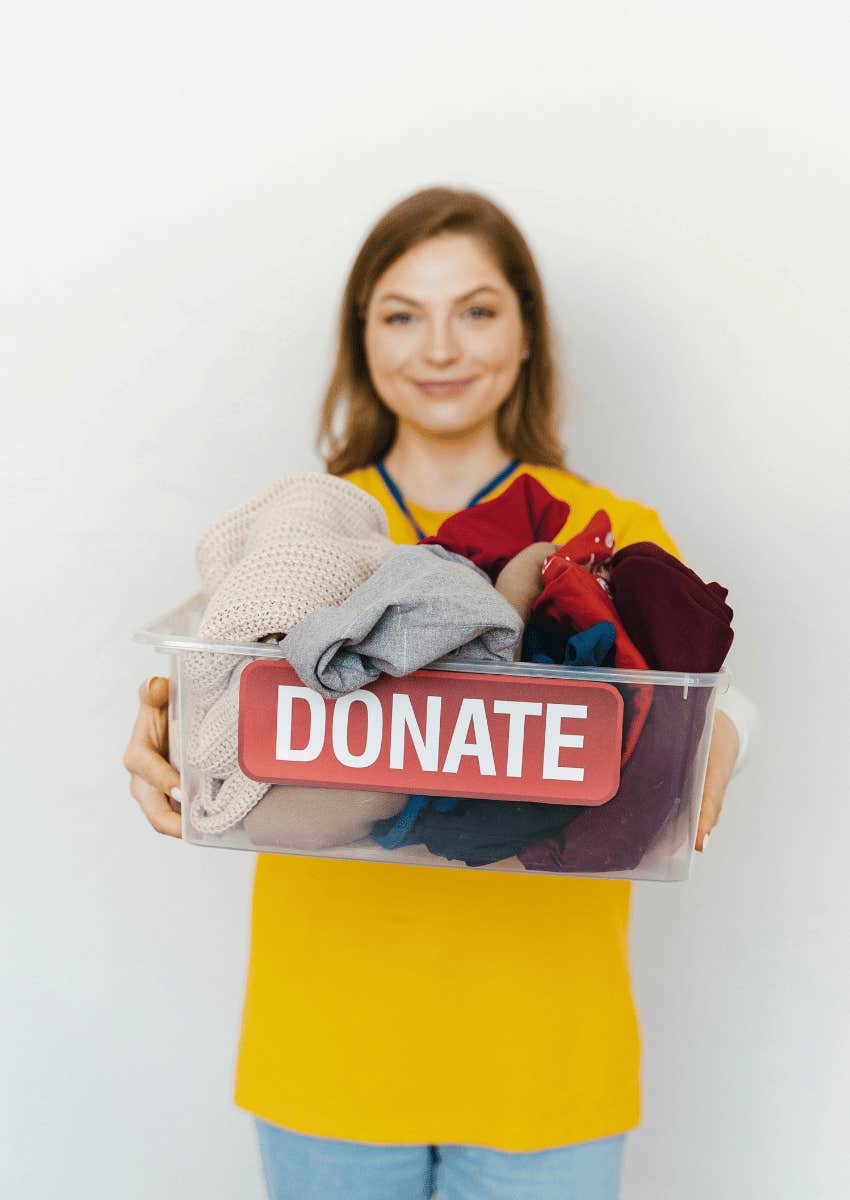 young woman holding a donation box of clothes