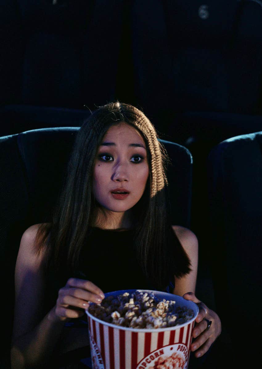 young woman holding a large bucket of popcorn
