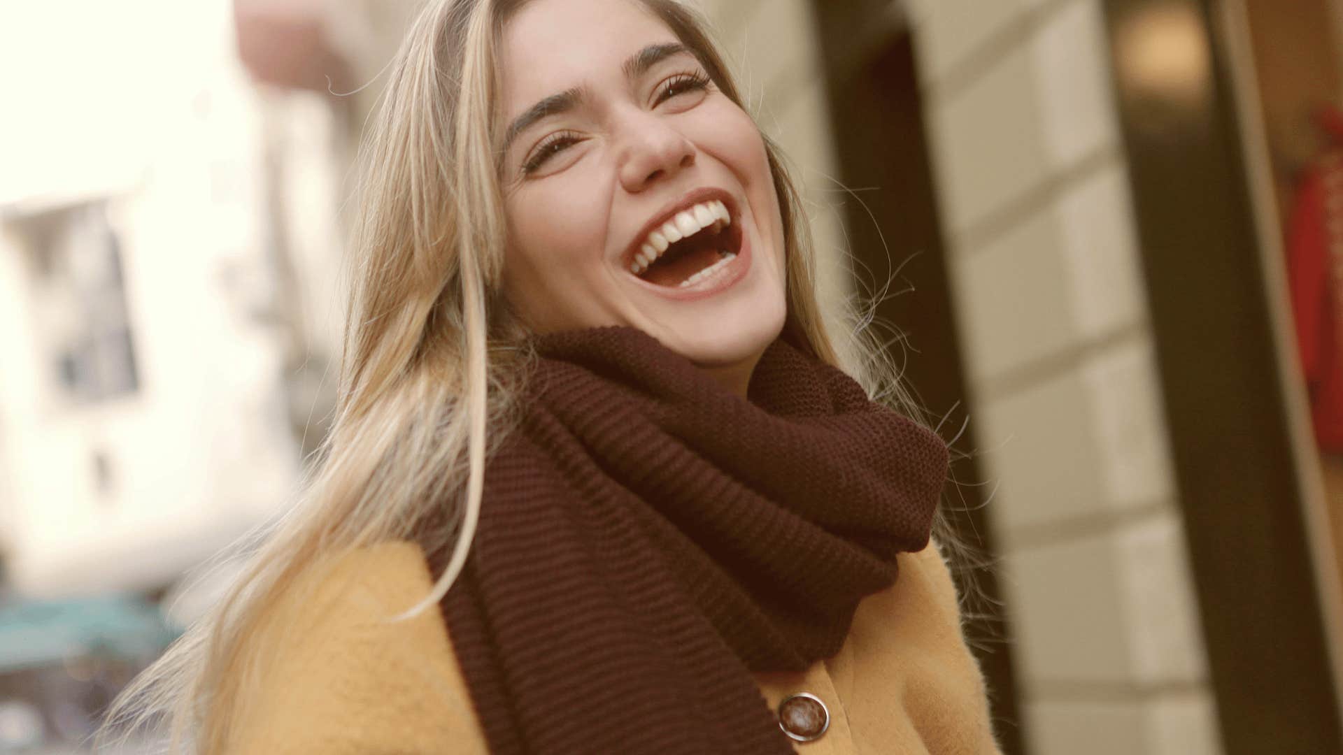 young woman laughing out loud to be unbothered