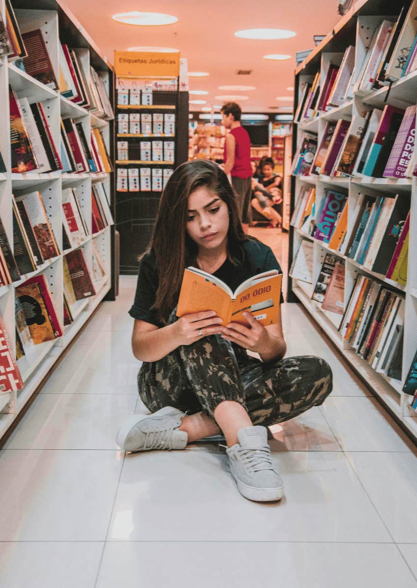 young woman sitting on the floor and reading