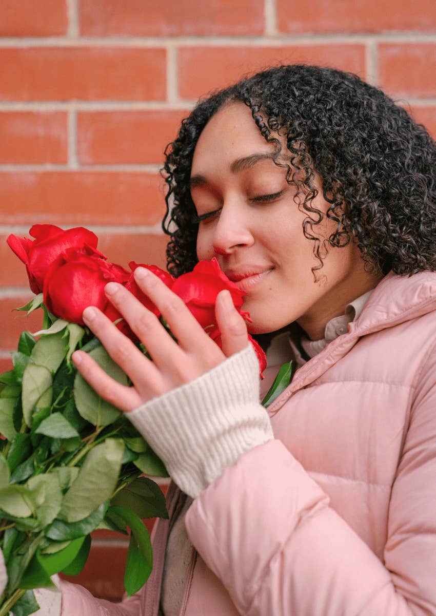 young woman smelling a bunch of roses