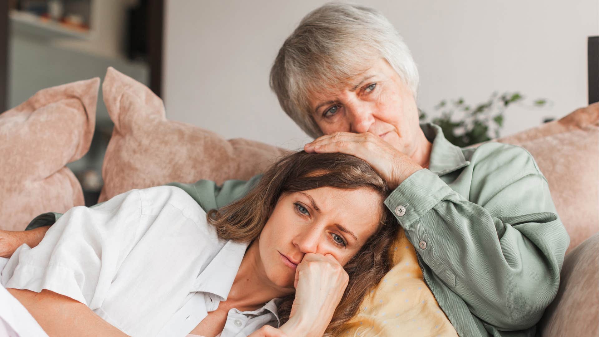 Sad person rests head on elders shoulder showing help after divorce