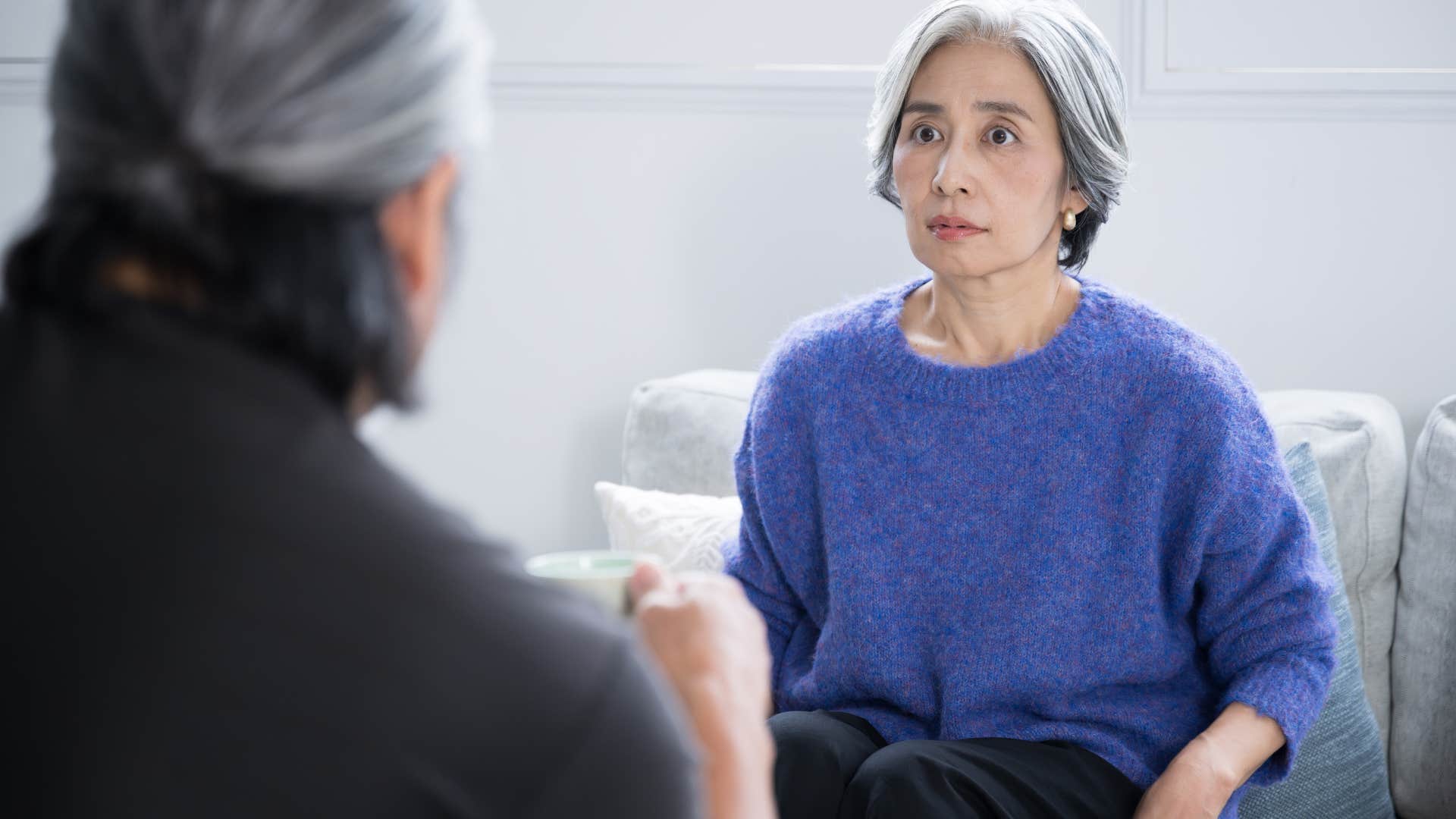 woman with tense body language talking to therapist