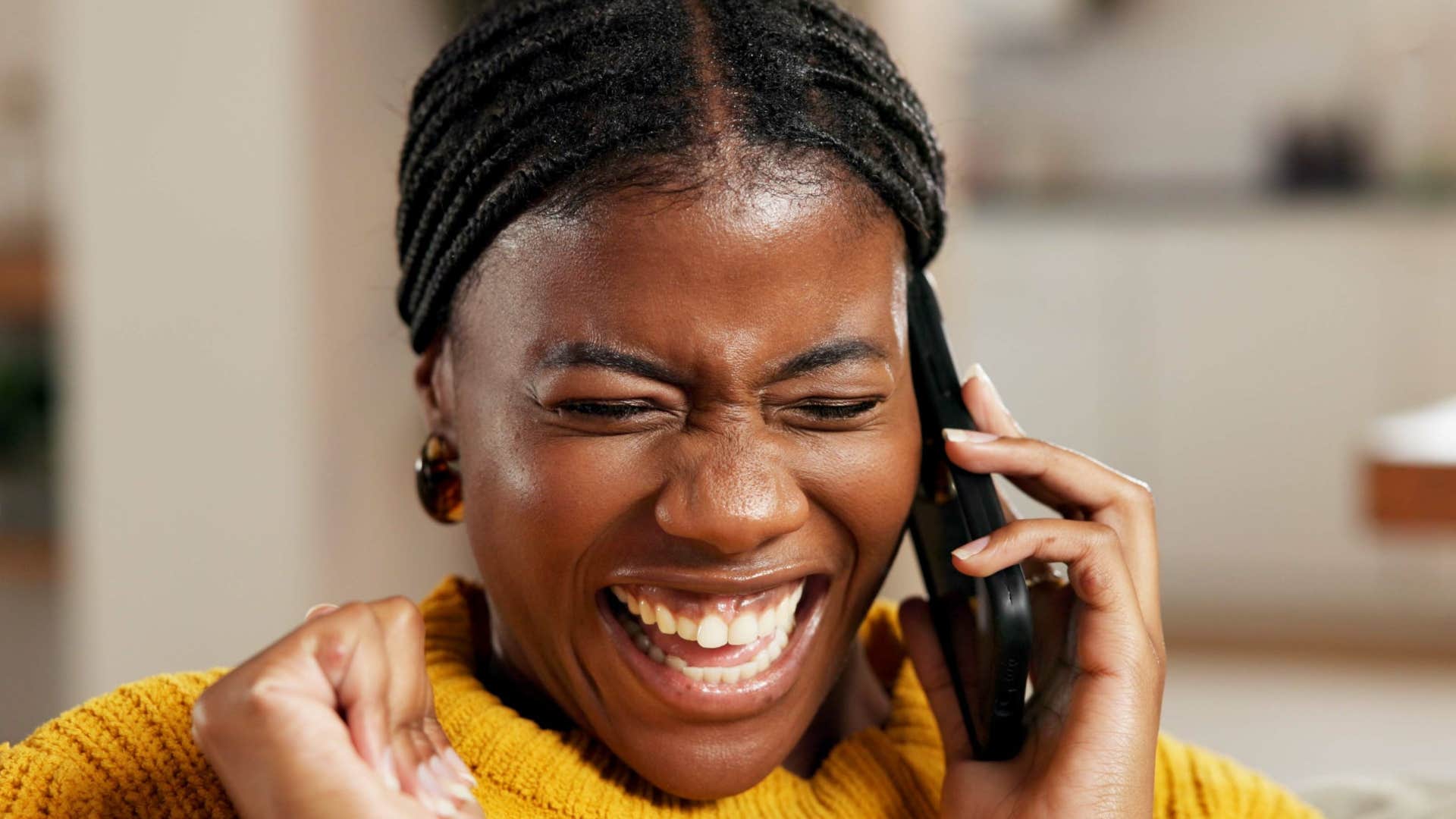 incredibly empathetic woman smiling on the phone talking to her parents