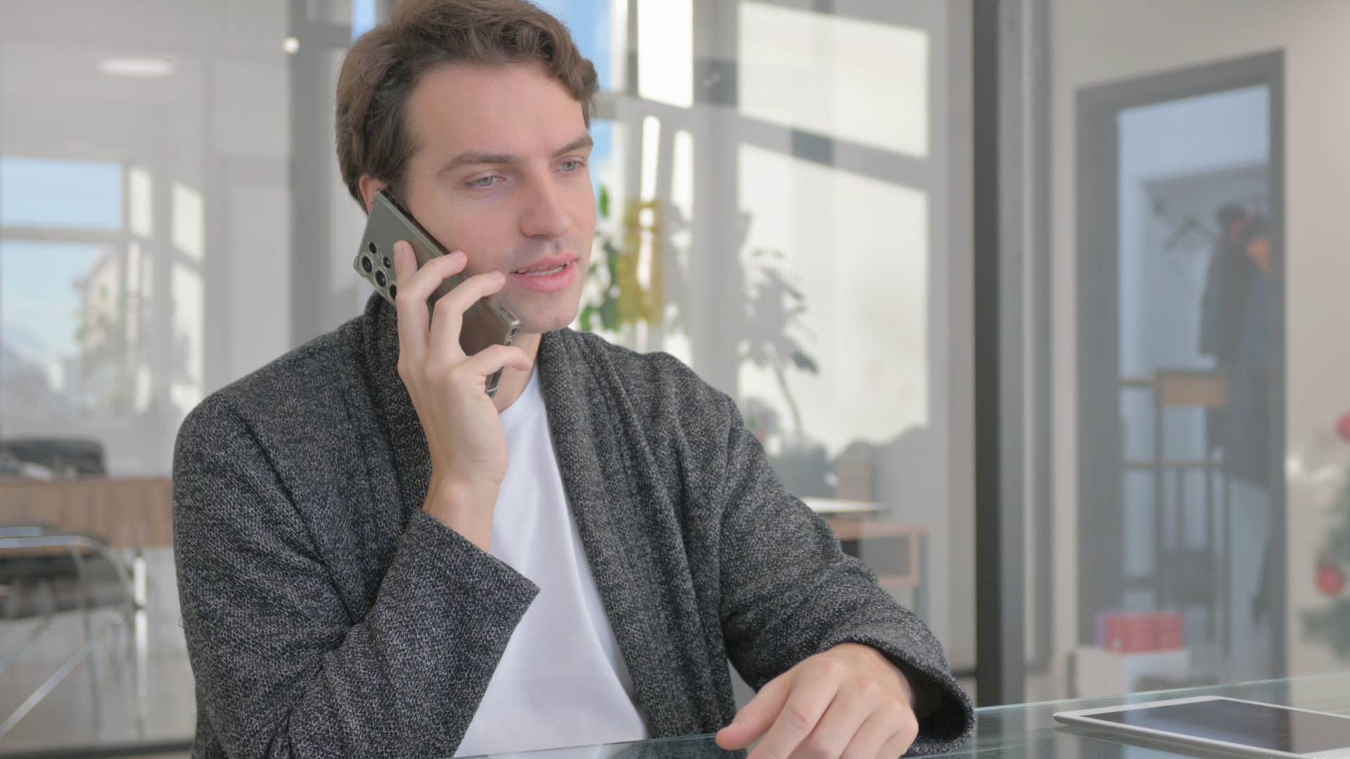 reflective man talking on the phone at work