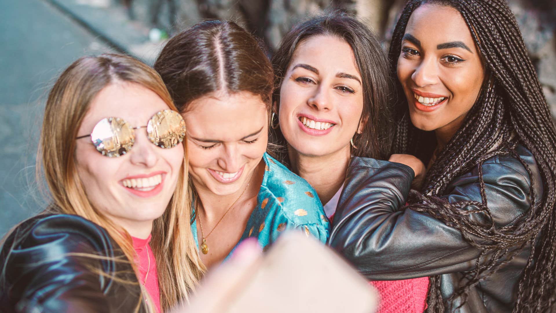 group of gen z women filming and taking photos non-stop on their phones