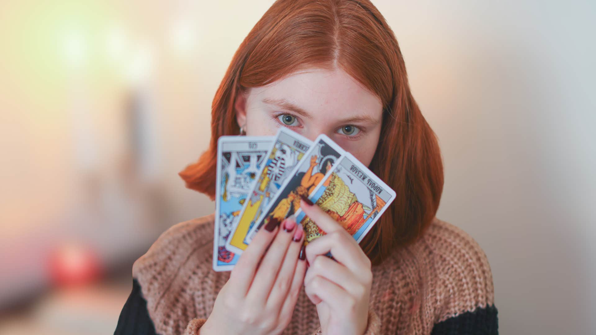Gen Z woman using astrology as a life guide holding tarot cards