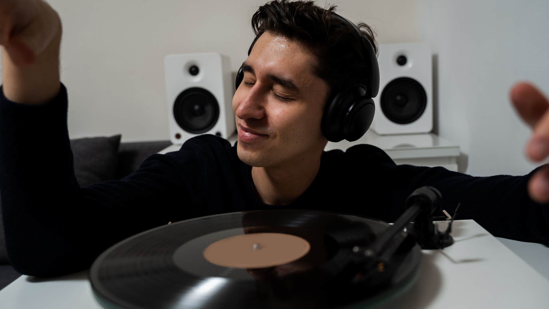 man who gets emotional listening to music smiling with a record player
