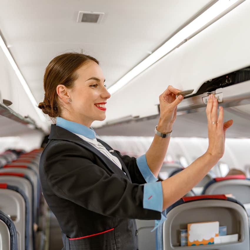female flight attendant closing overhead bin
