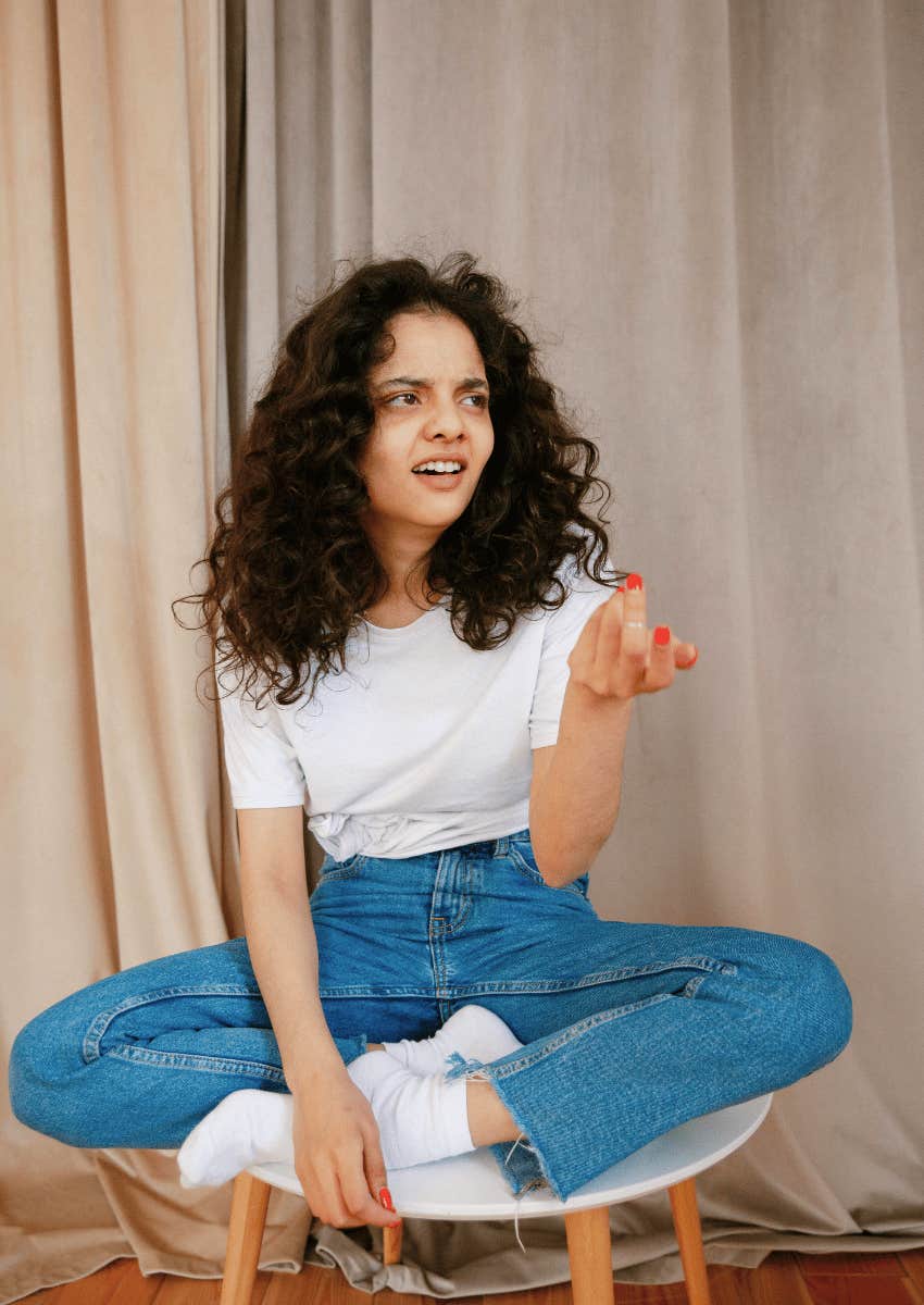 confused young woman sitting on stool