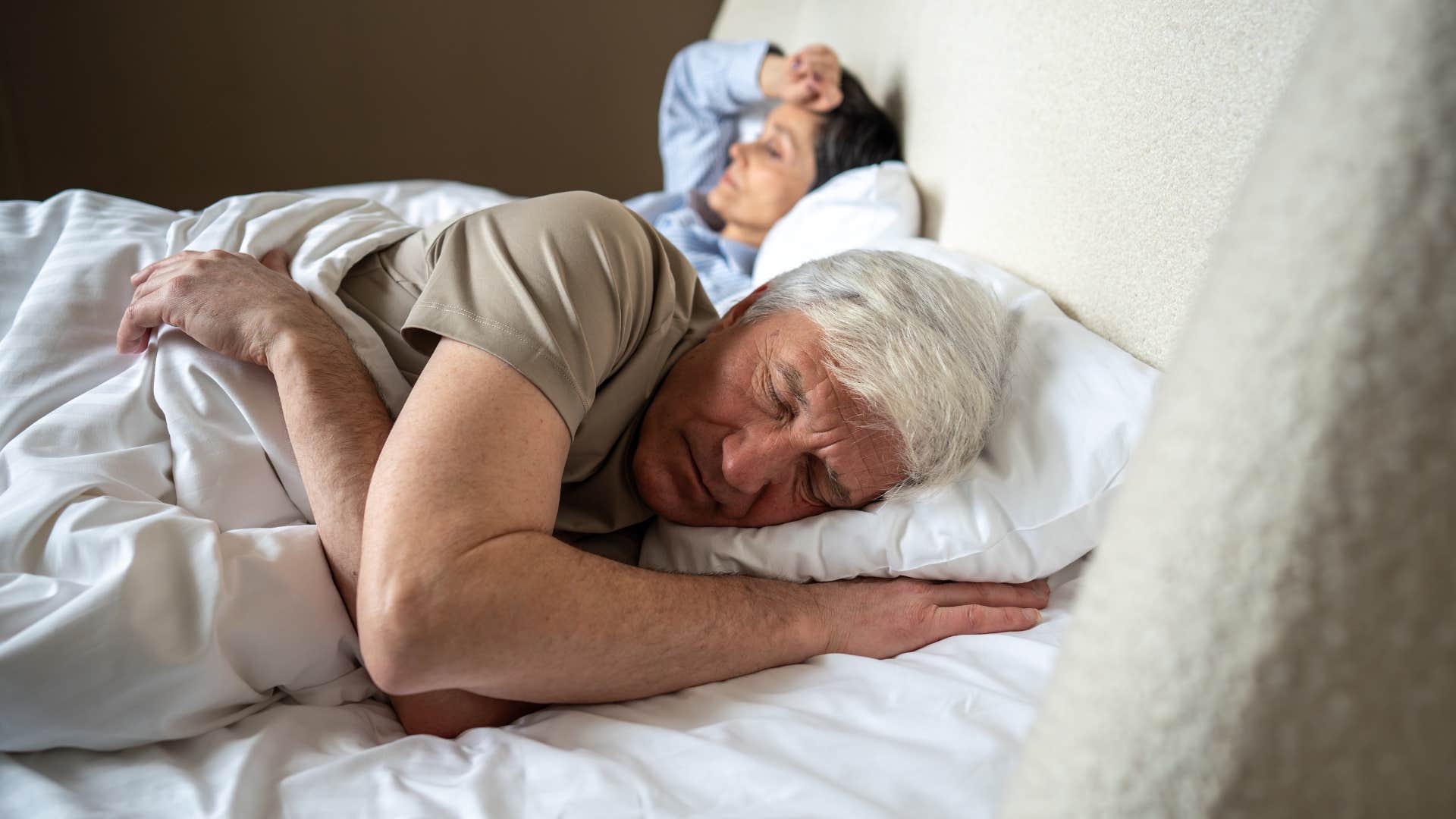 man laying in bed next to partner feeling resentful