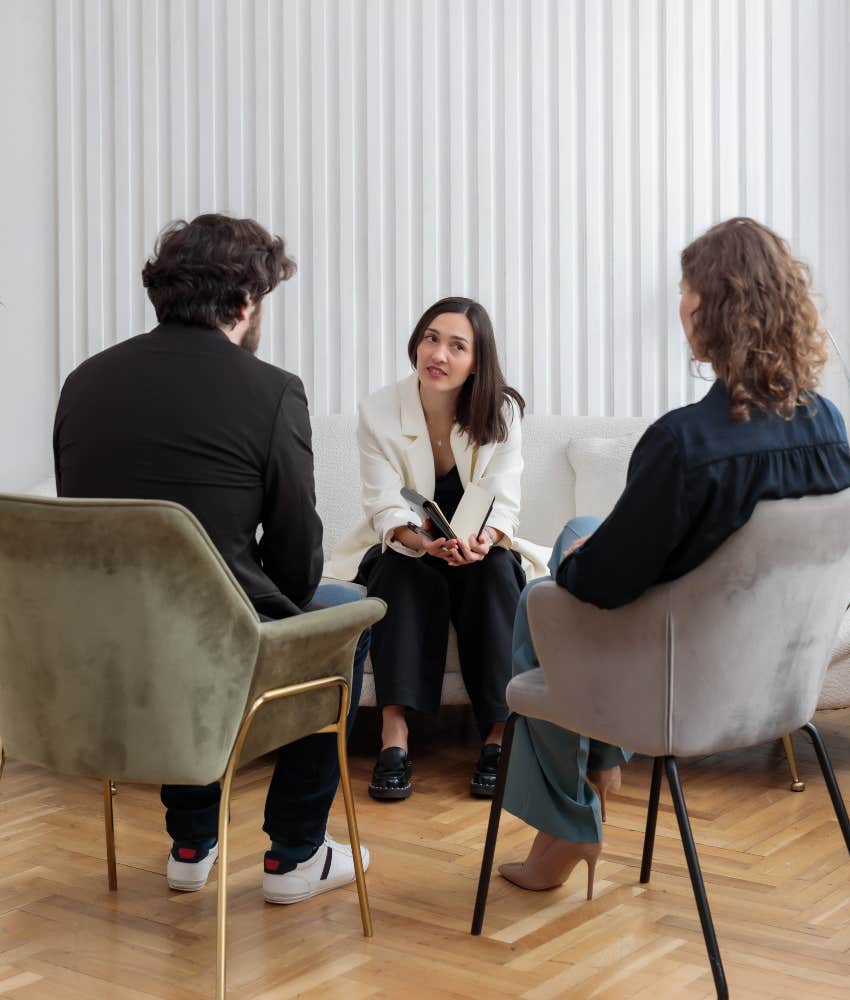 Concerned counselor leans in to help couple not argue 