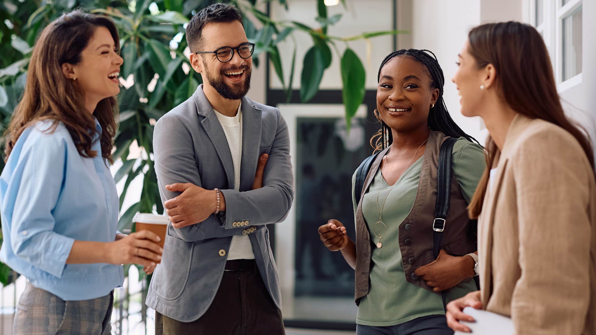 Man who remembers group dynamics smiling at co-workers.