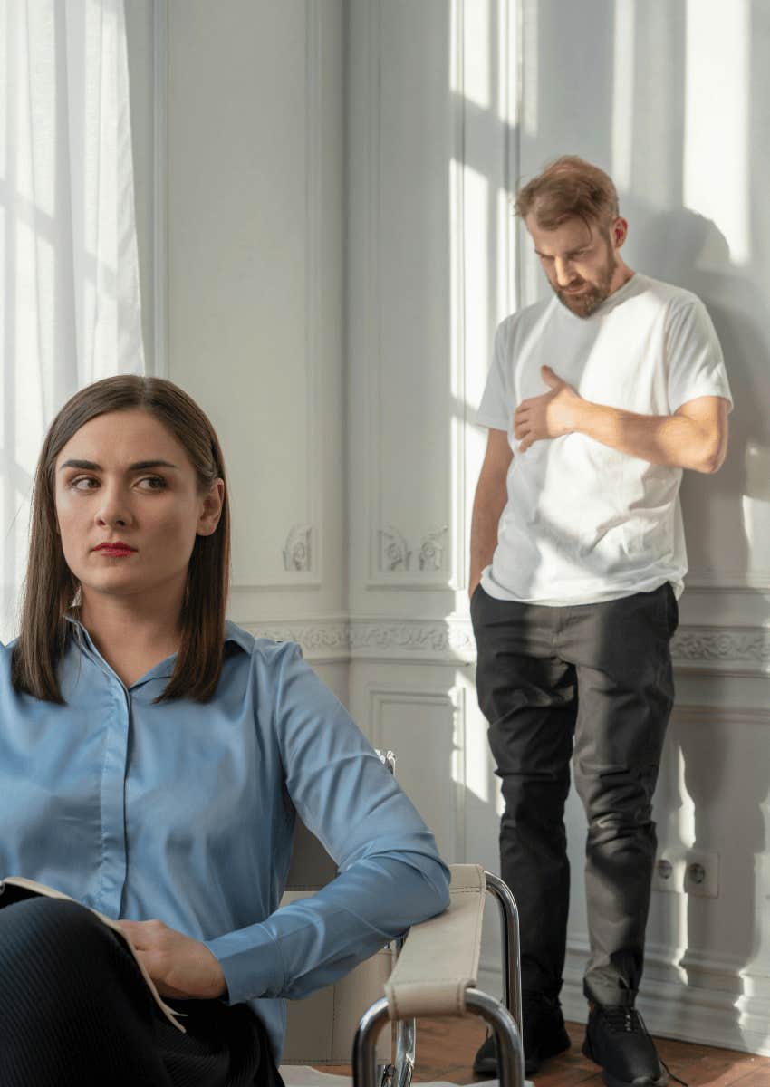 embarrassed man standing against wall