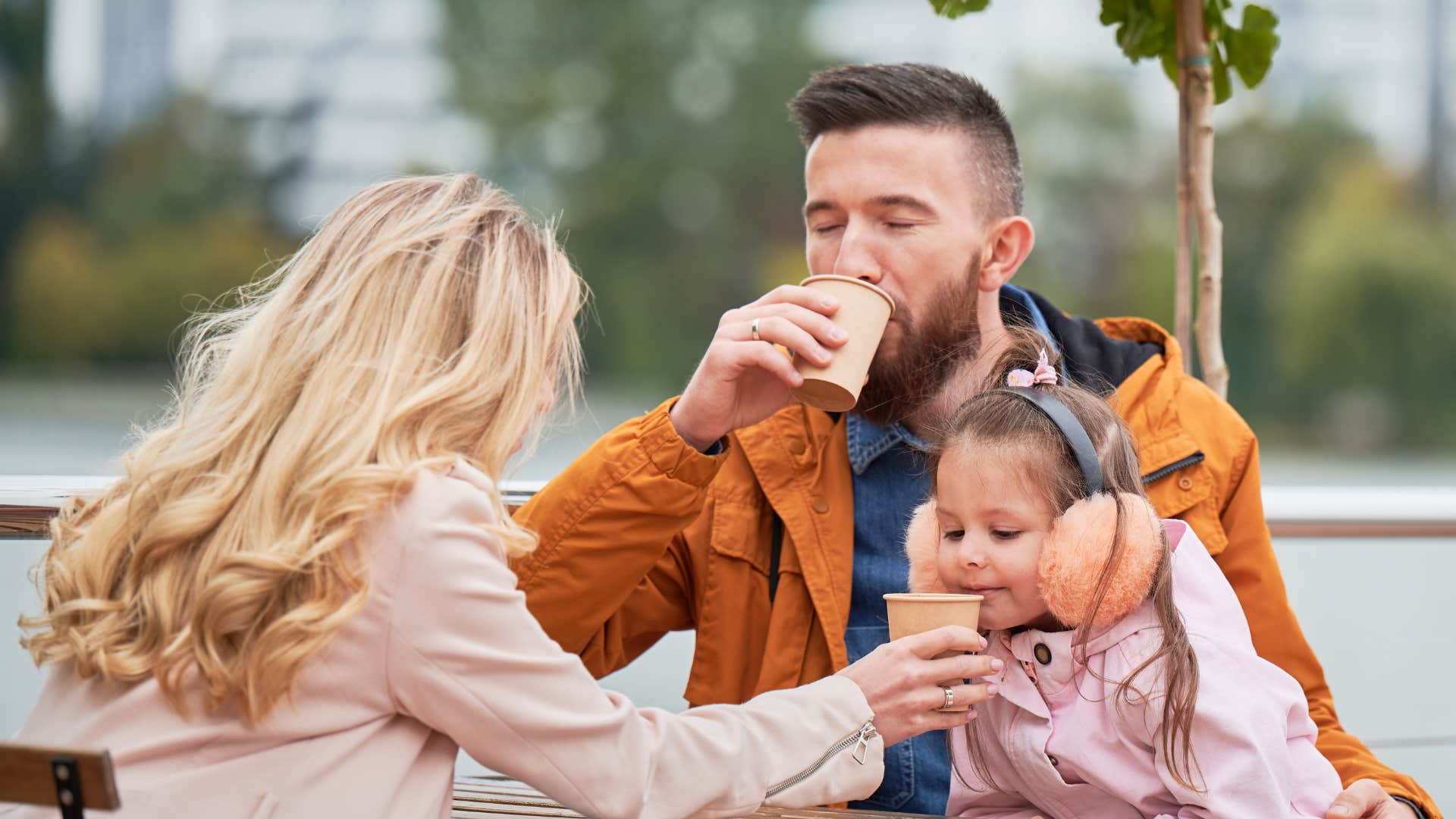 family drinking coffee sitting outside together