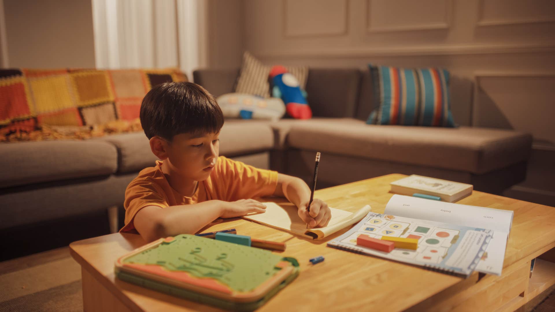 little boy doing his homework instead of sleeping