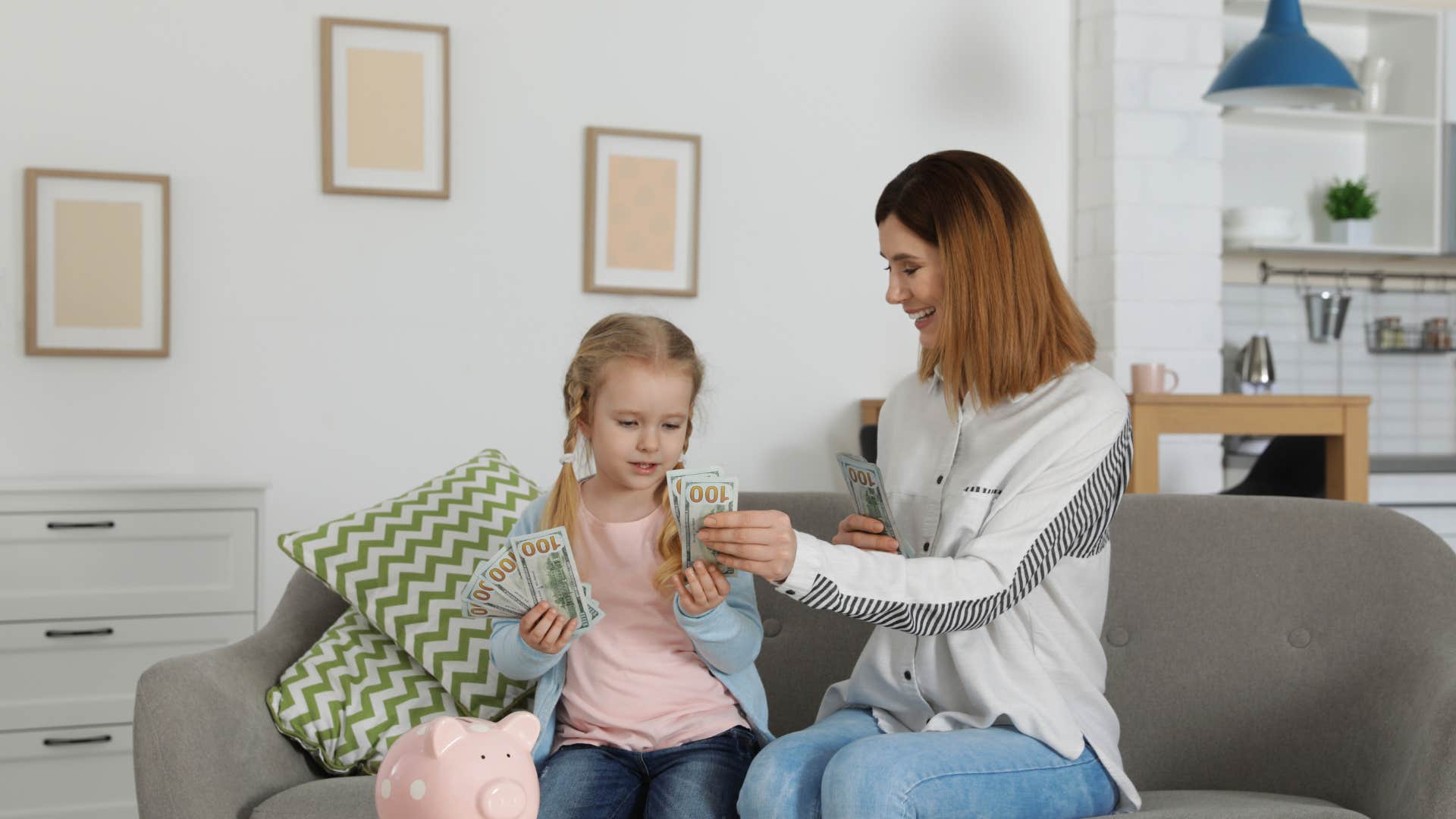 mom helping daughter count money telling her it doesn't grow on trees
