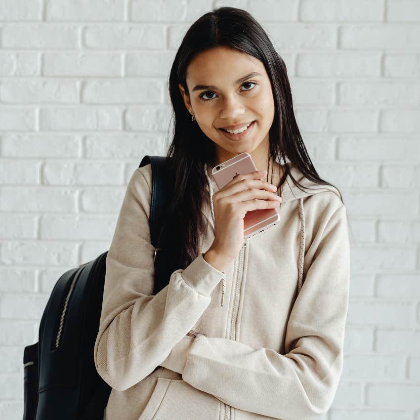 gen z student holding her phone needs a break from tech