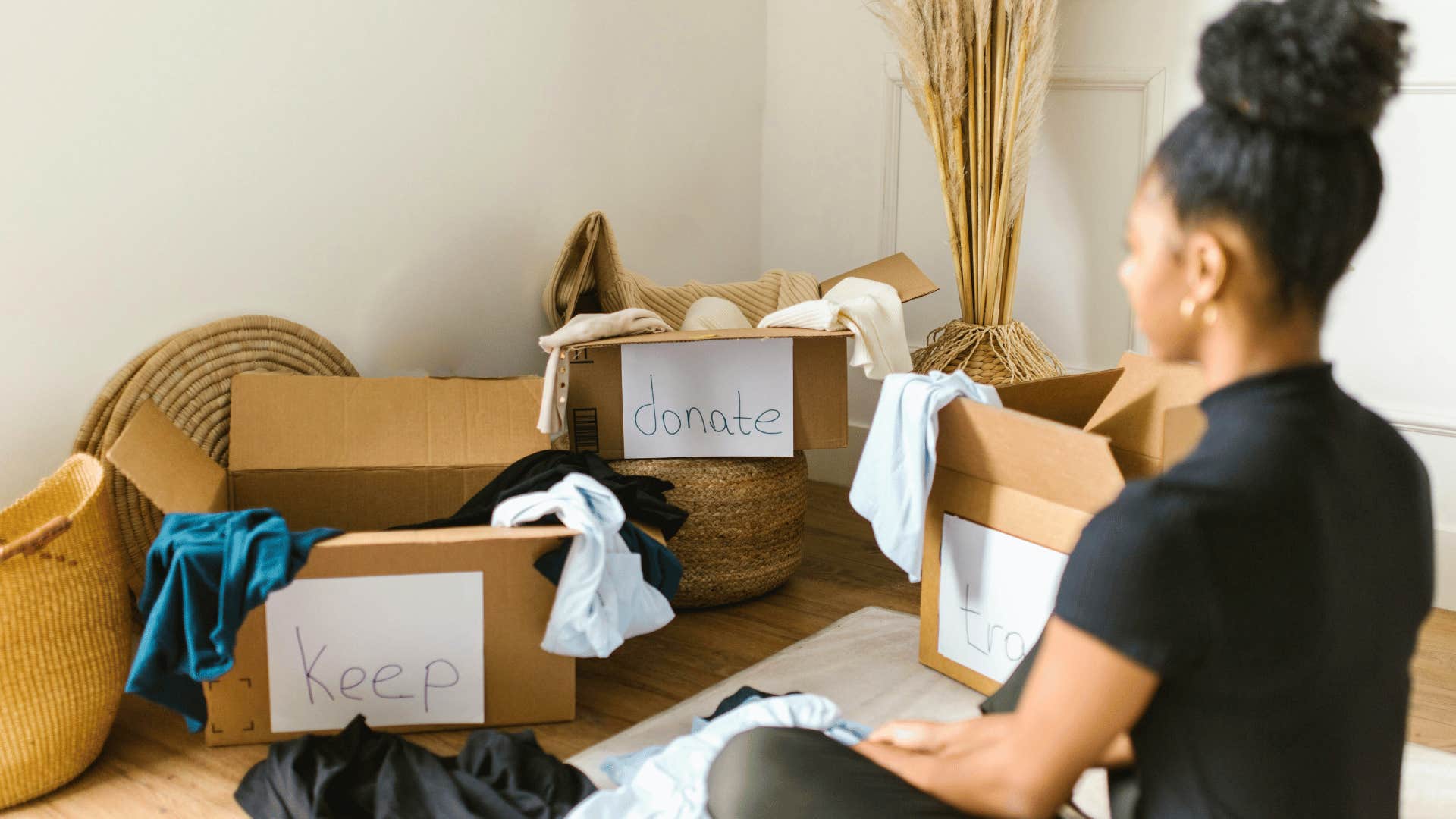 woman grabbing box and cleaning closet to feel less overwhelmed