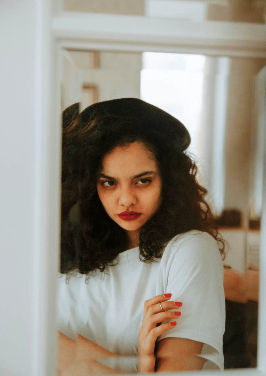 grumpy young woman staring at her reflection