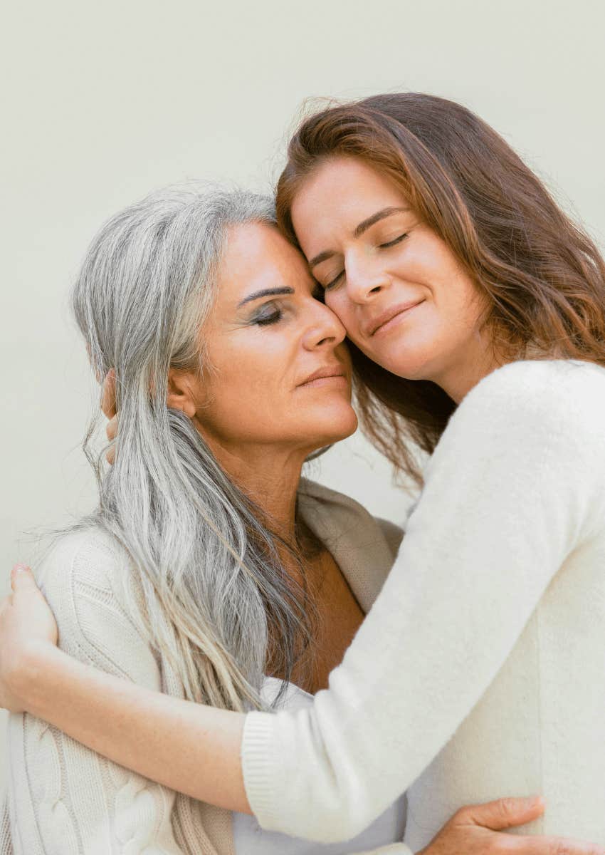 happy retired female couple hugging close