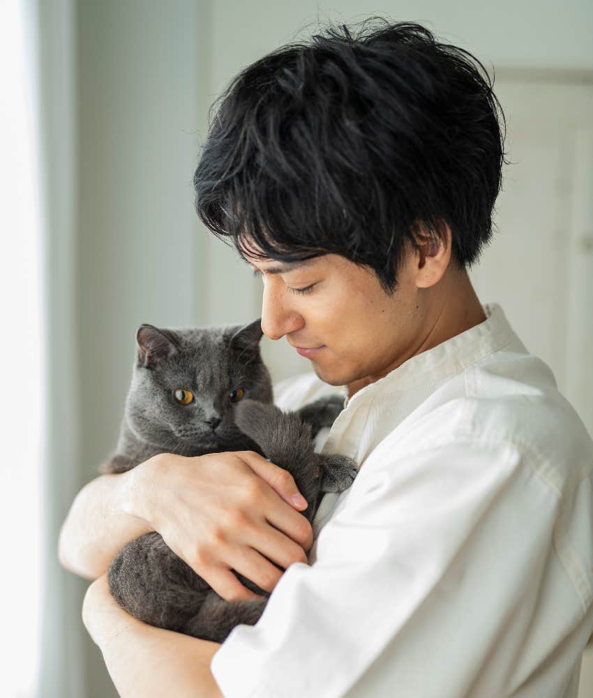 man holding gray cat in his arms helped in healing by cat