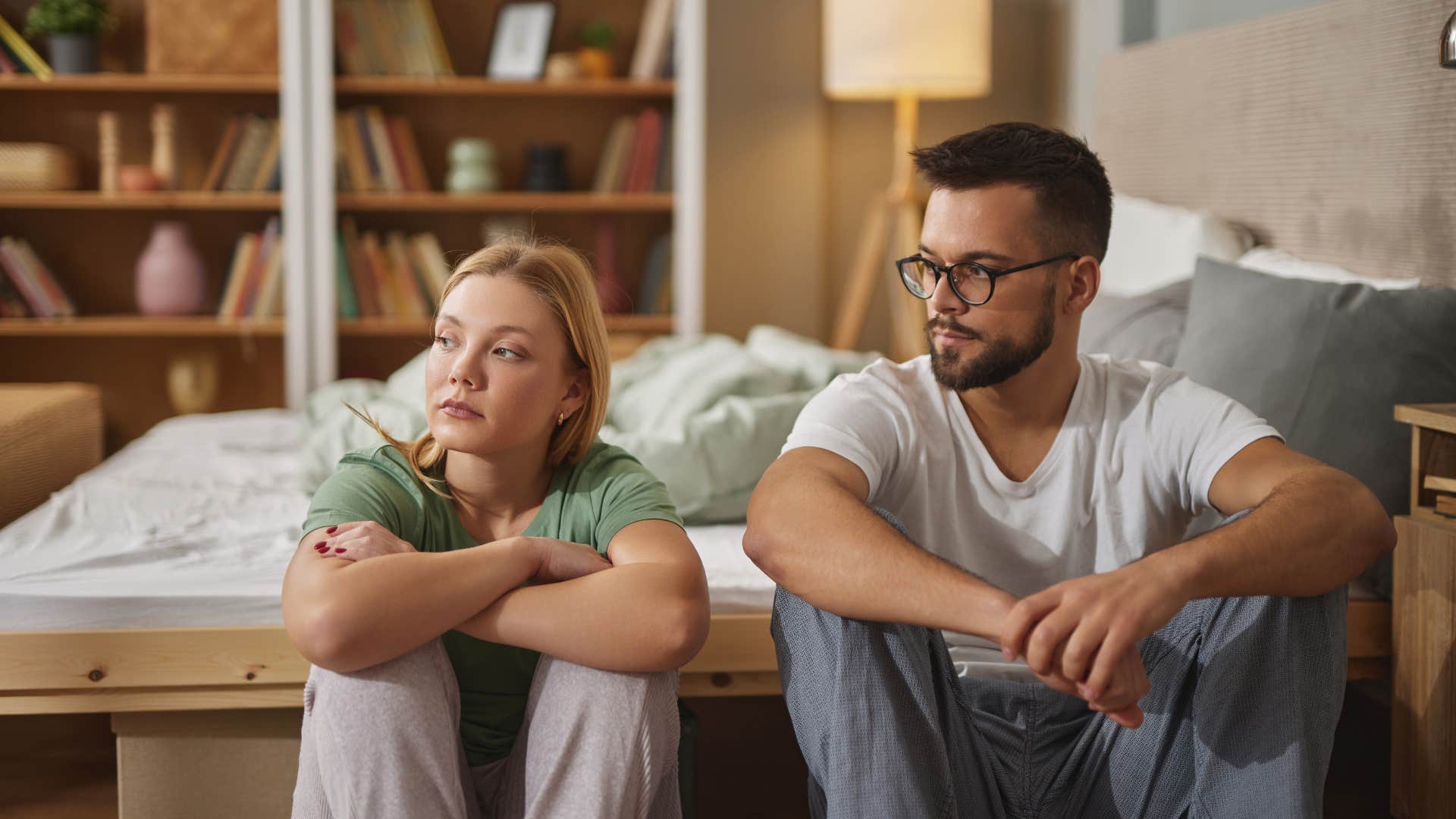 upset couple sitting on the floor in bedroom