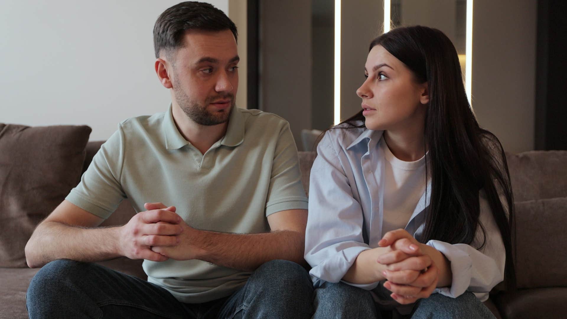 stressed couple looking at each other man asking why are you so defensive
