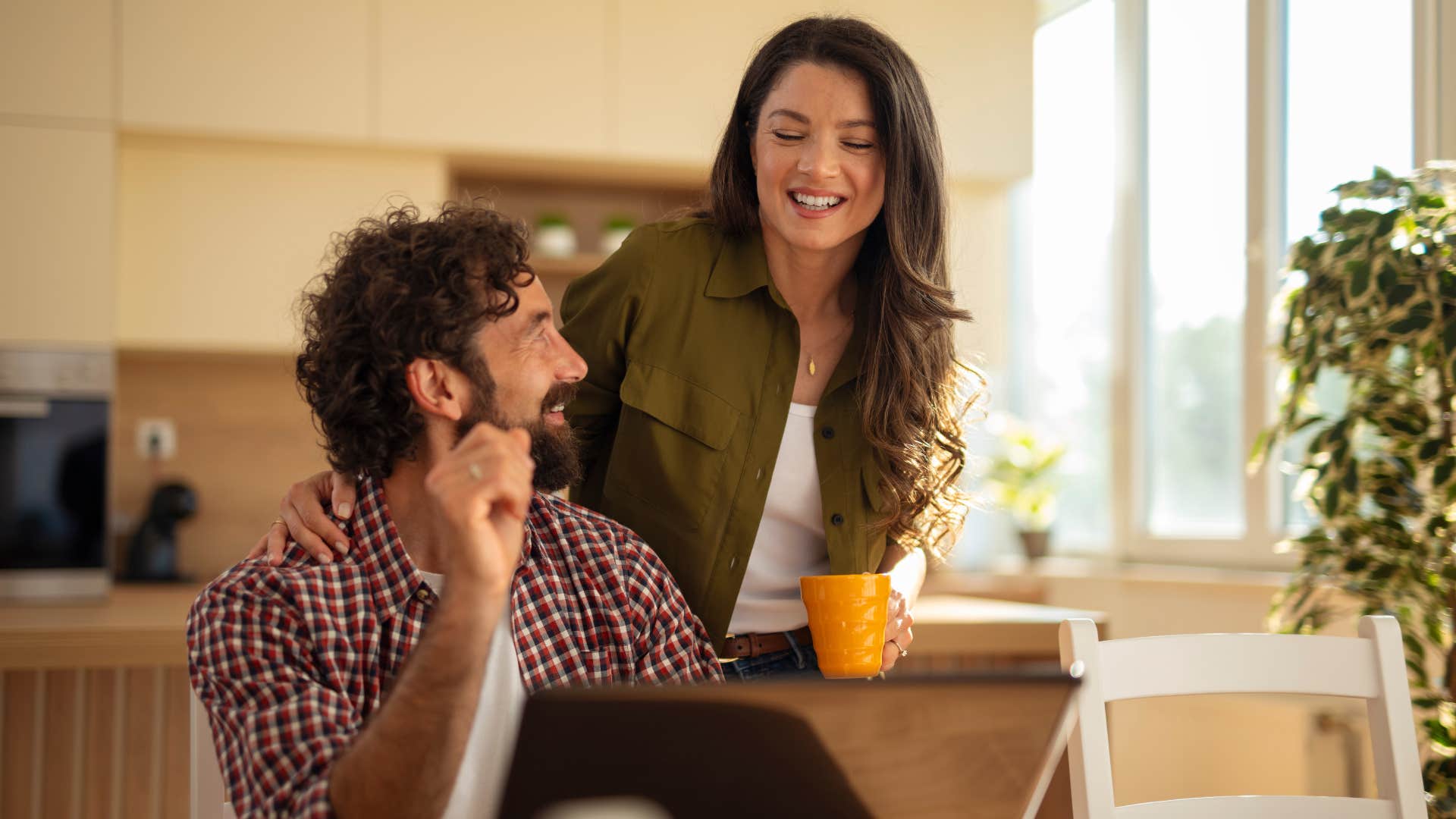Happy couple enjoying a conversation in a bright home kitchen