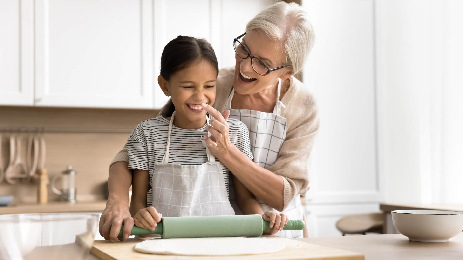 grandma and granddaughter baking together in kitchen