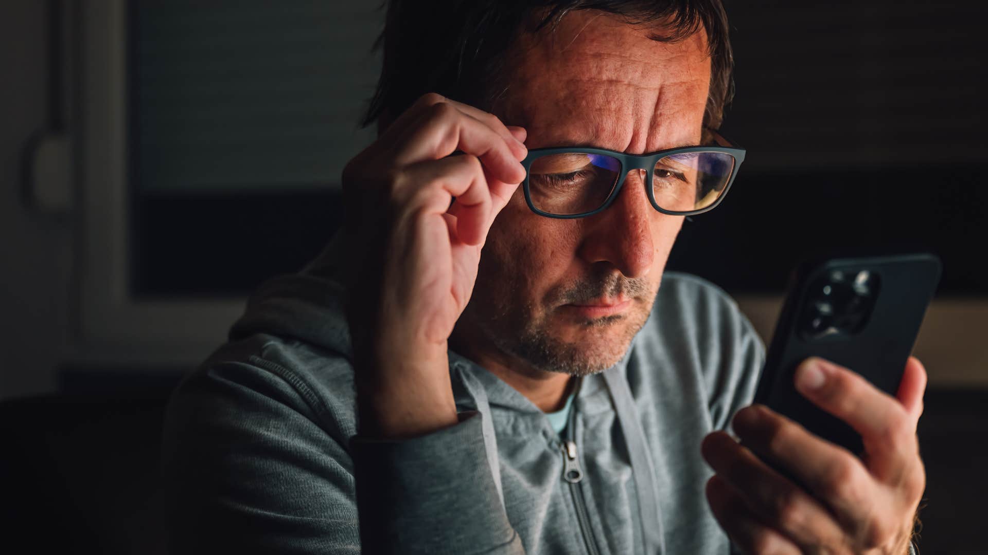 man who overindulges in toxic content online looking at his phone