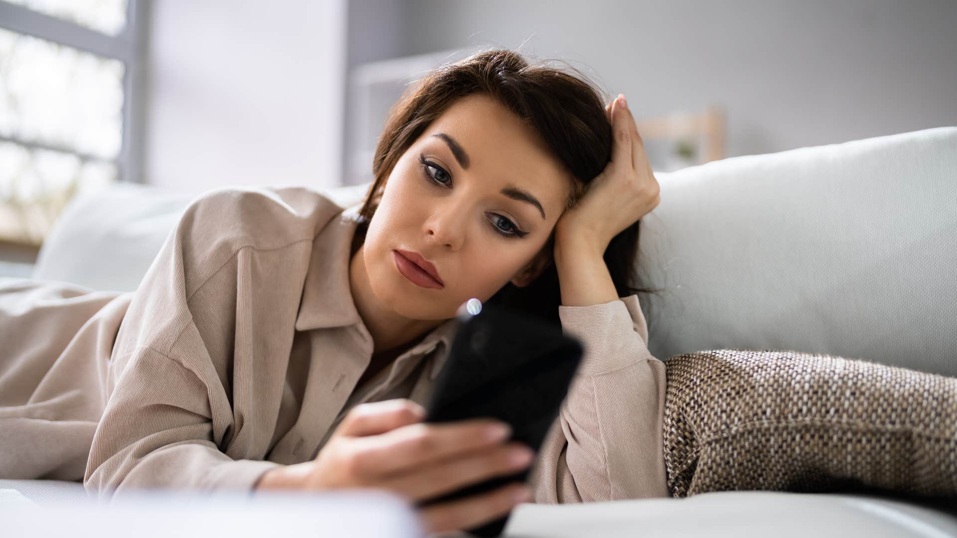 Annoyed person looks at hone showing disrespectful partner is ghosting