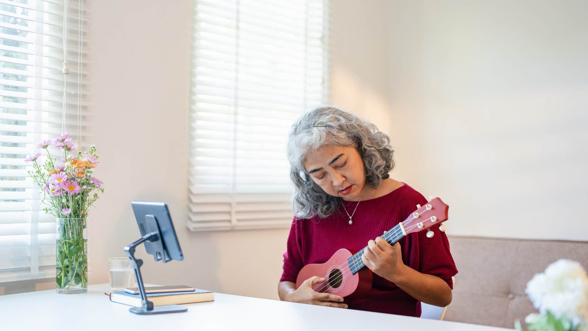 intelligent woman sitting and playing ukulele